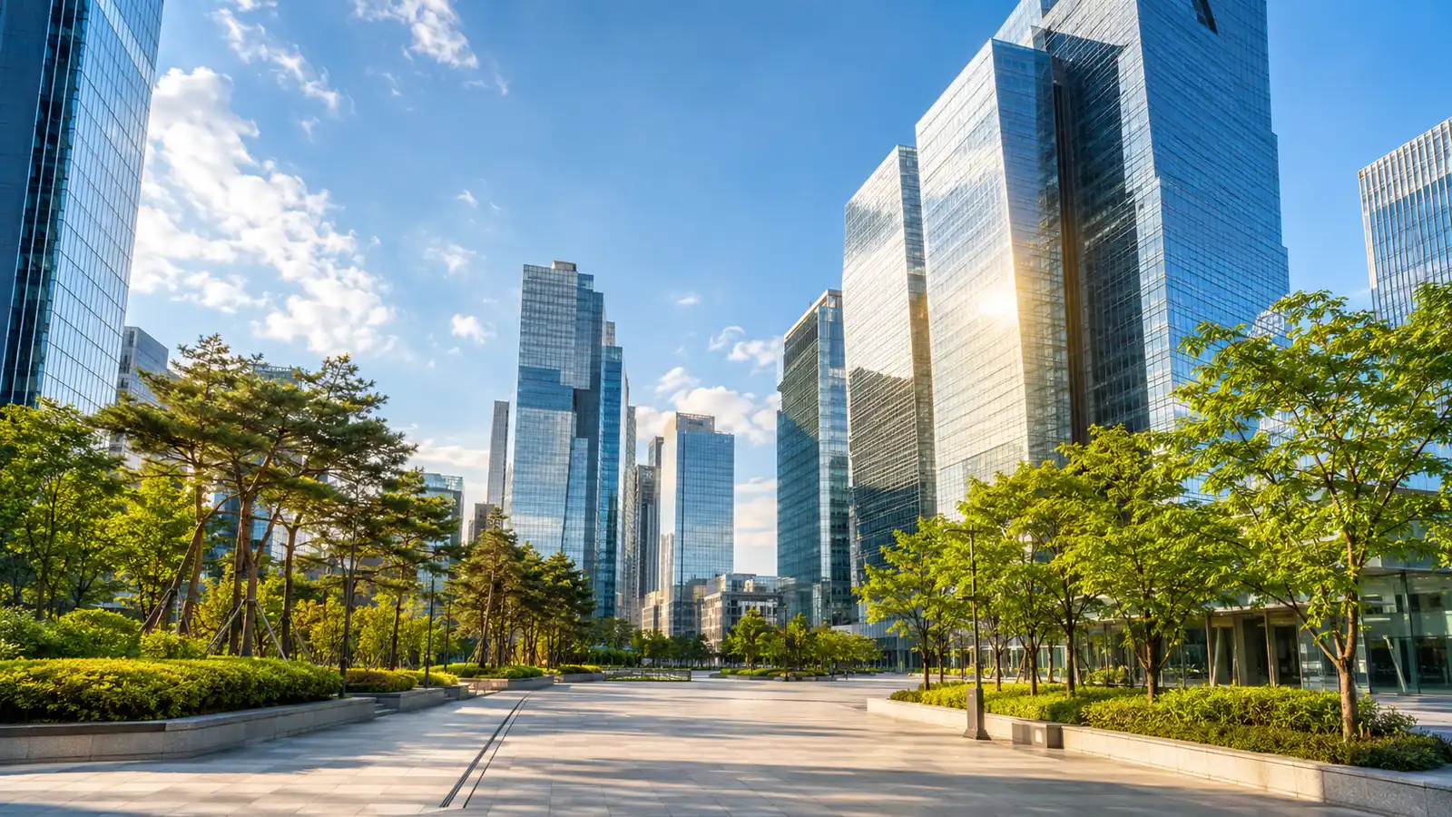 Glass office towers in a Seoul financial district catching warm morning light, with a tree-lined plaza below