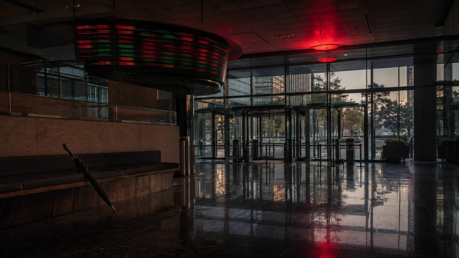 A red-lit brokerage lobby, one umbrella left against a bench